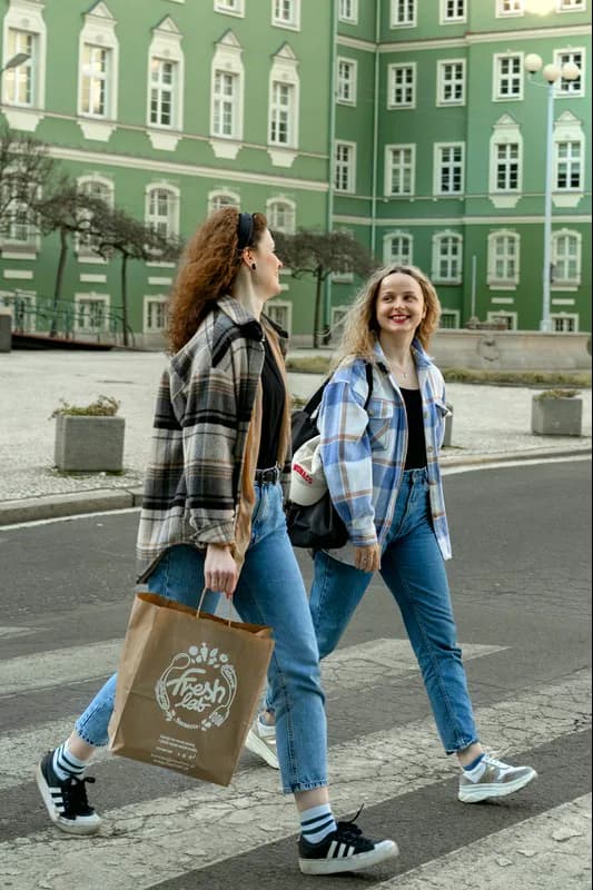 Dwie uśmiechnięte kobiety z torbą Freshlab na ulicy w Szczecinie
